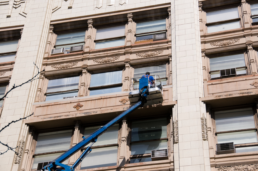 man cleaning facade and windows of a building